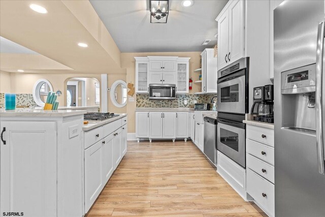 7 N Surrey Ave, Ventnor, NJ 08406 - kitchen with appliances with stainless steel finishes, backsplash, light wood-style flooring, white cabinetry, and recessed lighting