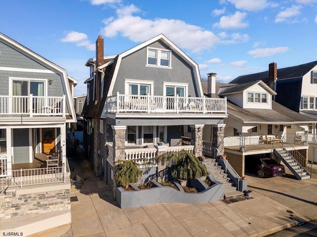7 N Surrey Ave, Ventnor, NJ 08406 - view of front of house with stairs, a chimney, a gambrel roof, covered porch, and stone siding