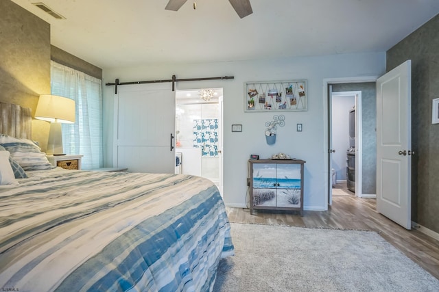 402 Harbour Cv Unit 402, Somers Point, NJ 08244 - bedroom featuring wood finished floors, a barn door, connected bathroom, ceiling fan, and baseboards