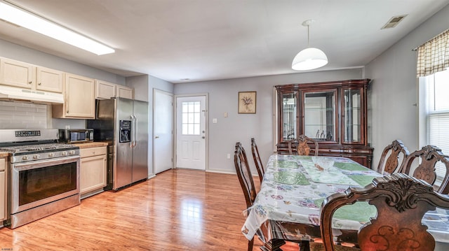 332 N Massachusetts Ave, Atlantic City, NJ 08401 - kitchen with appliances with stainless steel finishes, under cabinet range hood, light wood finished floors, decorative light fixtures, and tasteful backsplash