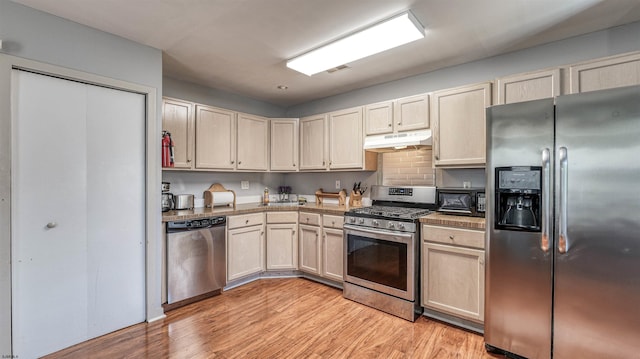 332 N Massachusetts Ave, Atlantic City, NJ 08401 - kitchen with appliances with stainless steel finishes, under cabinet range hood, light wood-style flooring, and light countertops
