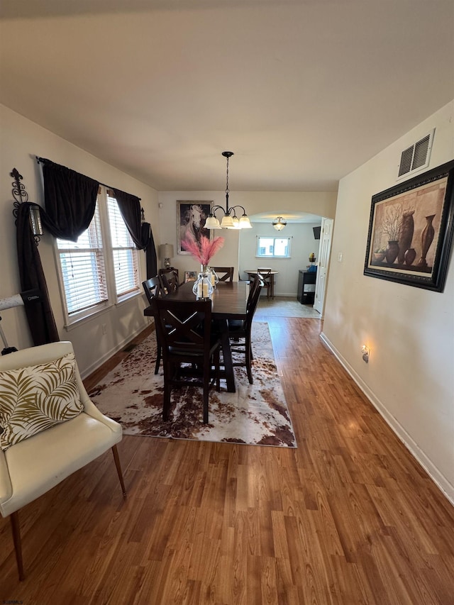 608 Walnut Ave, Northfield, NJ 08225 - dining space with baseboards, wood finished floors, a chandelier, and arched walkways