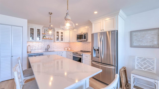 111 S 16th Ave Unit 510, Longport, NJ 08403 - kitchen with stainless steel appliances, a sink, backsplash, white cabinets, and a kitchen island
