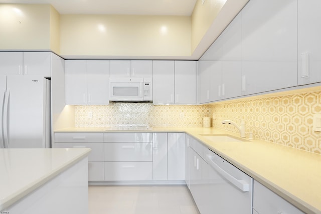 3007 Bayshore Ave Unit 23, Brigantine, NJ 08203 - kitchen with white appliances, a sink, white cabinets, light countertops, and tasteful backsplash