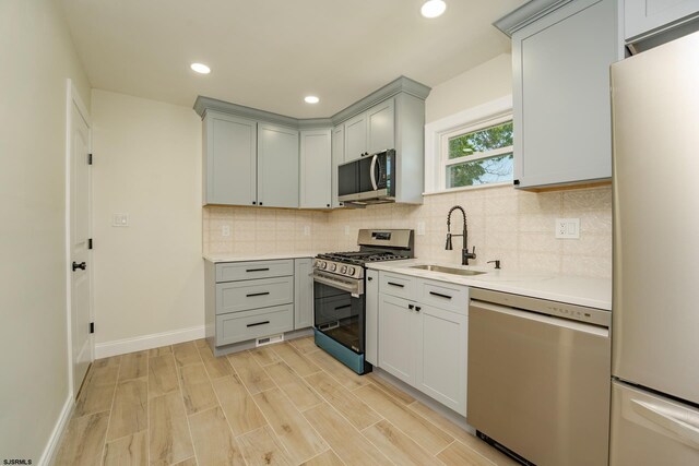 1013 New Rd, Northfield, NJ 08225 - kitchen with stainless steel appliances, a sink, gray cabinets, decorative backsplash, and recessed lighting