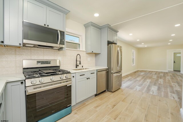 1013 New Rd, Northfield, NJ 08225 - kitchen with appliances with stainless steel finishes, a sink, backsplash, light wood-type flooring, and recessed lighting