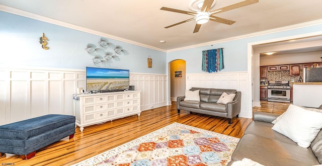 5003 Atlantic Ave Unit C04, Ventnor, NJ 08406 - living area with arched walkways, ornamental molding, light wood-style flooring, ceiling fan, and a wainscoted wall