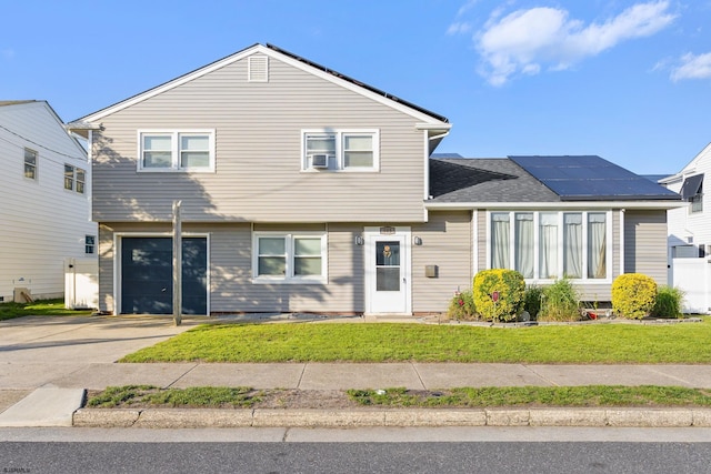 505 N Delavan Ave, Margate, NJ 08402 - view of front of property with solar panels, an attached garage, a front lawn, and concrete driveway