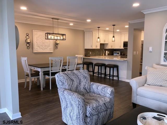 115 35th St Unit 1E, Sea Isle City, NJ 08243 - living area featuring ornamental molding, dark wood finished floors, recessed lighting, and baseboards