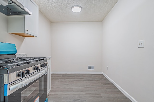 161 Sussex Pl Unit 161, Galloway Township, NJ 08205 - kitchen featuring gas range, range hood, white cabinetry, light wood-style flooring, and a textured ceiling