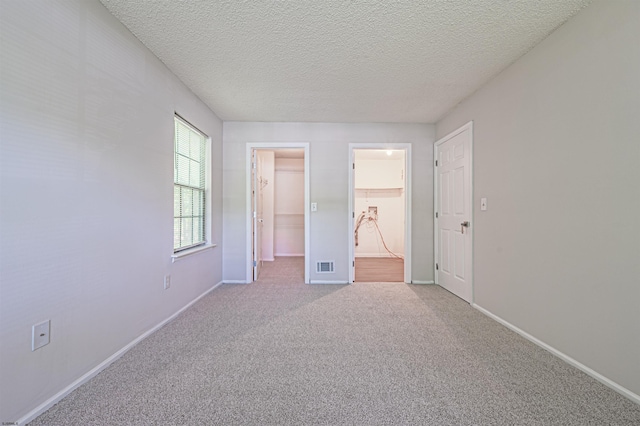 161 Sussex Pl Unit 161, Galloway Township, NJ 08205 - unfurnished bedroom featuring a walk in closet, carpet, a textured ceiling, baseboards, and ensuite bath