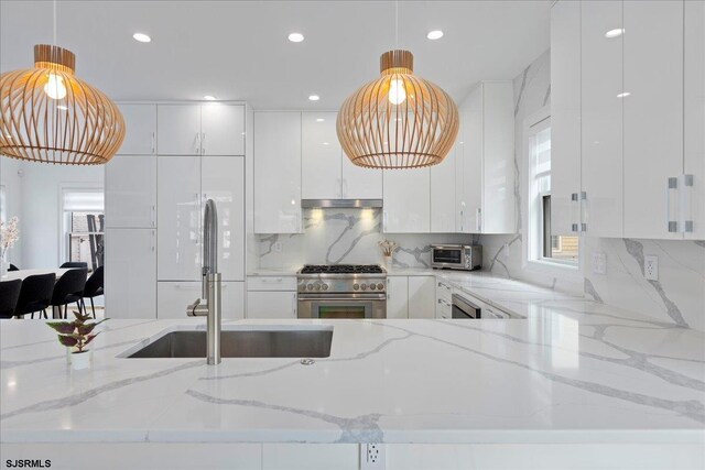 1A N Douglas Ave, Margate, NJ 08402 - kitchen featuring high end stainless steel range, modern cabinets, under cabinet range hood, a sink, and white cabinets