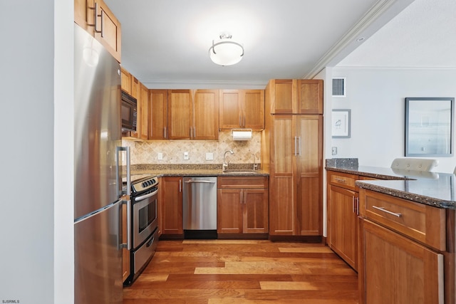 111 S 16th Ave Unit 605, Longport, NJ 08403 - kitchen featuring stainless steel appliances, dark stone countertops, light wood-type flooring, crown molding, and a peninsula