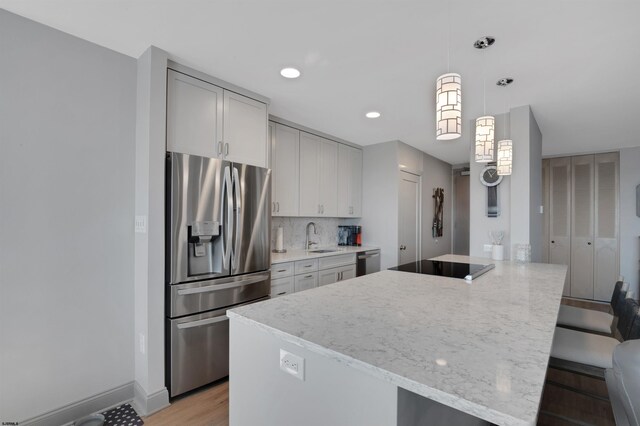 5000 Boardwalk Unit 1806, Ventnor, NJ 08406 - kitchen with stainless steel appliances, a peninsula, light wood-style floors, light stone counters, and gray cabinets