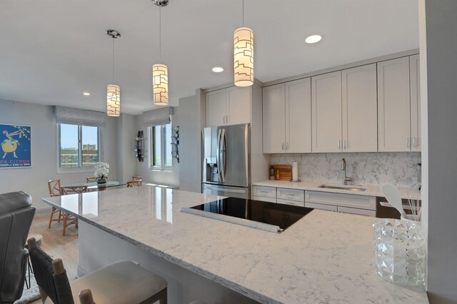 5000 Boardwalk Unit 1806, Ventnor, NJ 08406 - kitchen featuring stainless steel fridge with ice dispenser, light stone counters, black electric cooktop, decorative light fixtures, and recessed lighting