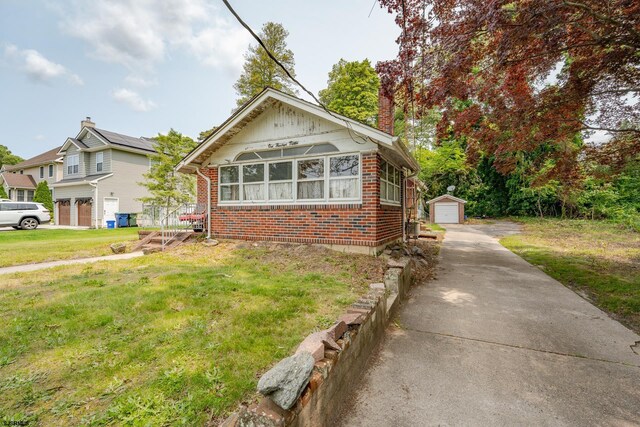 112 Kirklin Ave, Linwood, NJ 08221 - bungalow featuring brick siding, a front yard, a chimney, an outbuilding, and a detached garage