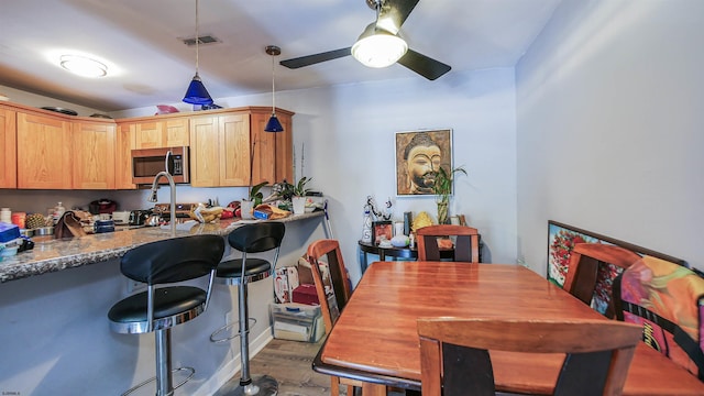 275 Heather Croft Unit 275, Egg Harbor Township, NJ 08234 - kitchen featuring stainless steel microwave, wood finished floors, a kitchen bar, a ceiling fan, and decorative light fixtures