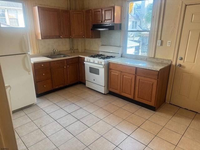 118 N Morris Ave, Atlantic City, NJ 08401 - kitchen featuring white appliances, ventilation hood, light countertops, brown cabinets, and plenty of natural light
