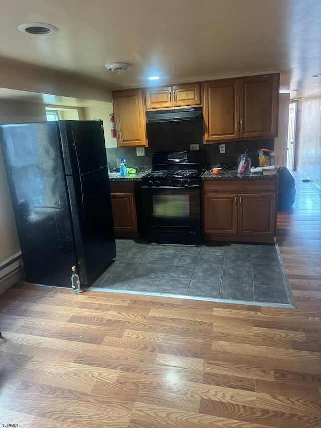 118 N Morris Ave, Atlantic City, NJ 08401 - kitchen with black appliances, under cabinet range hood, light wood-style flooring, and tasteful backsplash