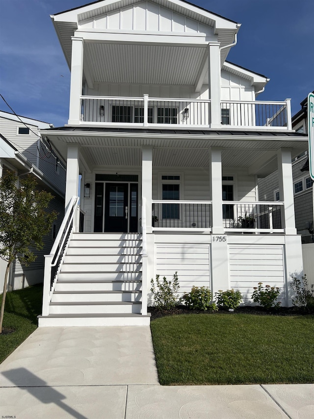 1755 Bay Ave, Ocean City, NJ 08226 - view of front of property with board and batten siding, a porch, a balcony, a front lawn, and stairway