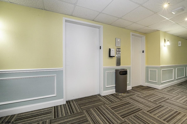 812 Ocean Ave Unit 112, Ocean City, NJ 08226 - empty room featuring carpet floors, a drop ceiling, a wainscoted wall, and a decorative wall