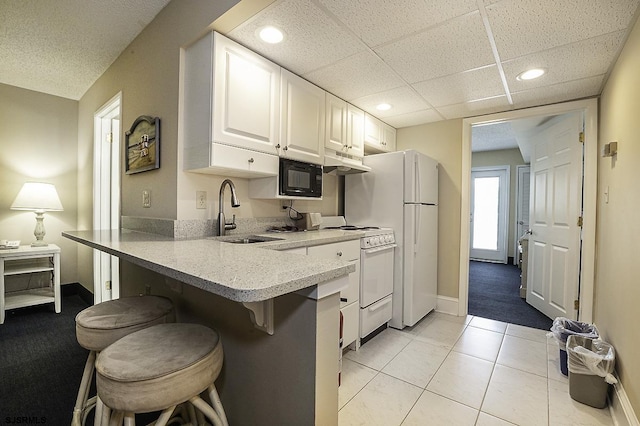 812 Ocean Ave Unit 112, Ocean City, NJ 08226 - kitchen with white appliances, under cabinet range hood, white cabinetry, a kitchen breakfast bar, and a peninsula