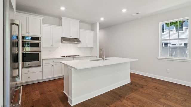 845 Broadway, West Cape May, NJ 08204 - kitchen with under cabinet range hood, appliances with stainless steel finishes, light countertops, dark wood-style flooring, and an island with sink