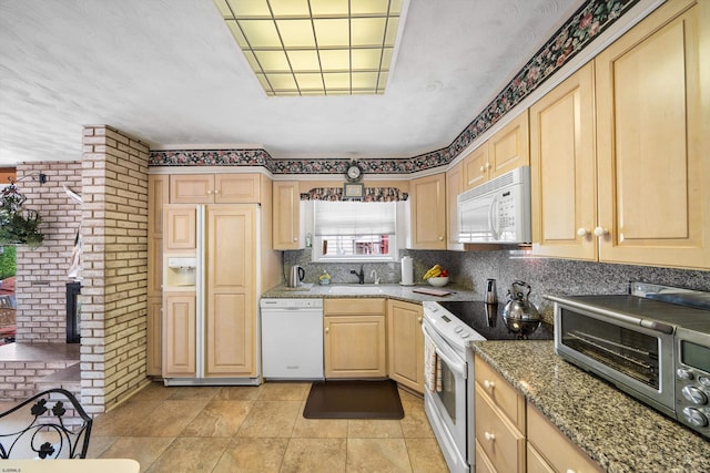 8407 Fremont Ave, Margate, NJ 08402 - kitchen featuring white appliances, light brown cabinets, brick wall, light stone countertops, and backsplash