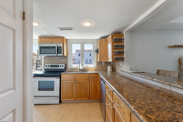 151 N Annapolis Ave Unit D, Atlantic City, NJ 08401 - kitchen featuring stainless steel appliances, decorative backsplash, light tile patterned floors, and brown cabinetry