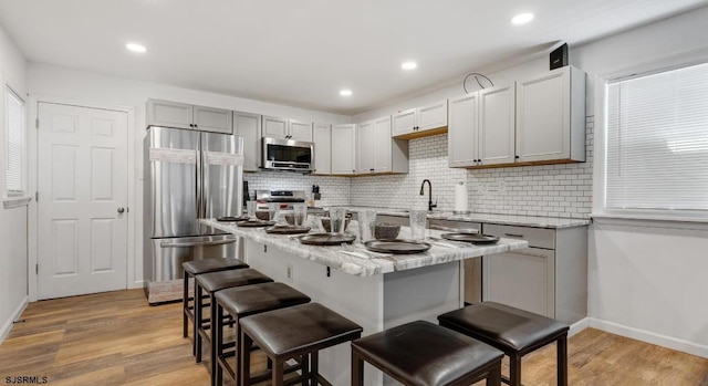 1620 N Michigan Ave, Atlantic City, NJ 08401 - kitchen featuring appliances with stainless steel finishes, backsplash, a breakfast bar, light wood-style floors, and recessed lighting