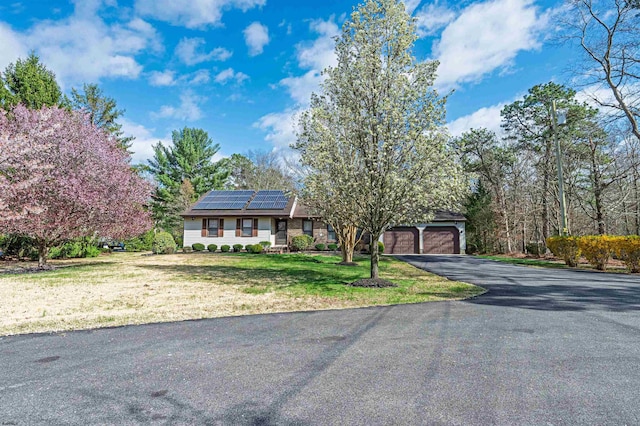 628 1st Ave, Galloway Township, NJ 08205 - view of front of home featuring roof mounted solar panels, driveway, and a front lawn
