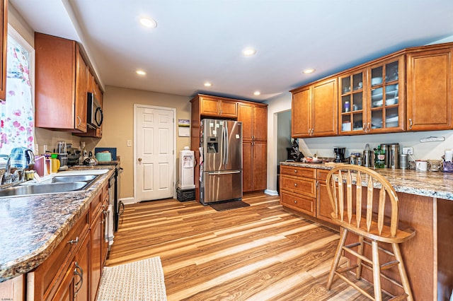 628 1st Ave, Galloway Township, NJ 08205 - kitchen with stainless steel refrigerator with ice dispenser, brown cabinetry, light wood-style flooring, recessed lighting, and glass insert cabinets
