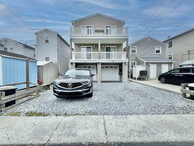 331 Asbury Ave Unit 2, Ocean City, NJ 08226 - view of front of property with a shed, an attached garage, gravel driveway, and a balcony
