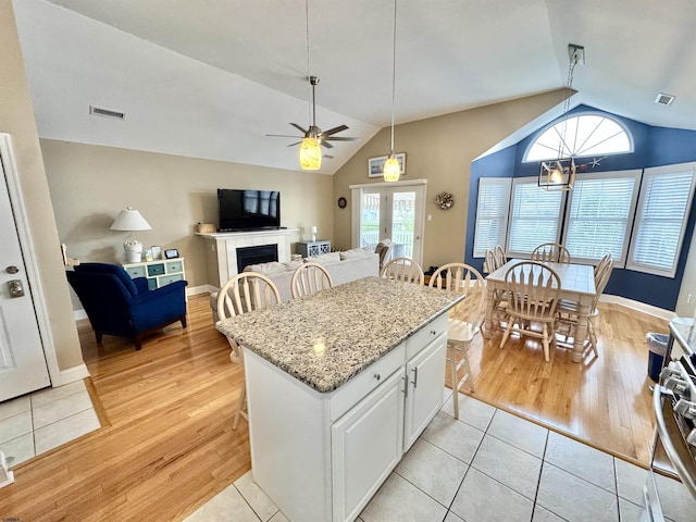 331 Asbury Ave Unit 2, Ocean City, NJ 08226 - kitchen with vaulted ceiling, a ceiling fan, light wood-style floors, stainless steel range, and white cabinetry
