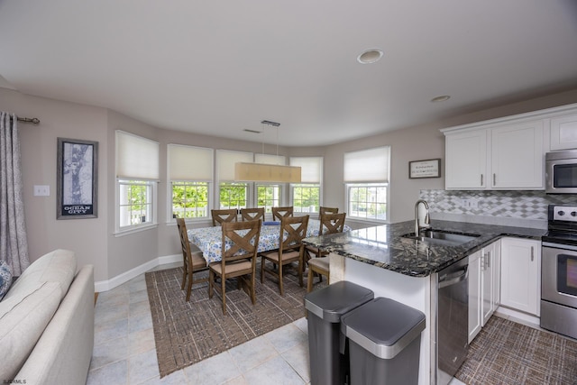 1611 Central Ave Unit 2, Ocean City, NJ 08226 - kitchen featuring stainless steel appliances, white cabinets, dark stone countertops, backsplash, and a peninsula