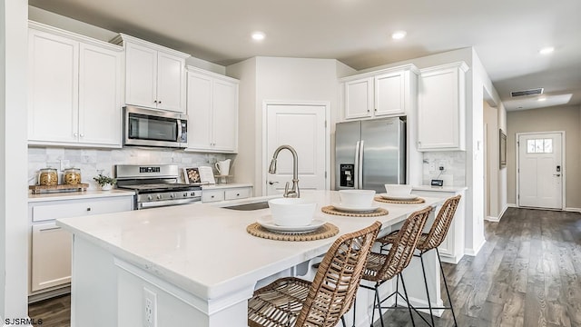 57 Siegtown Rd, Middle Township, NJ 08210 - kitchen featuring stainless steel appliances, light countertops, a kitchen island with sink, backsplash, and a breakfast bar