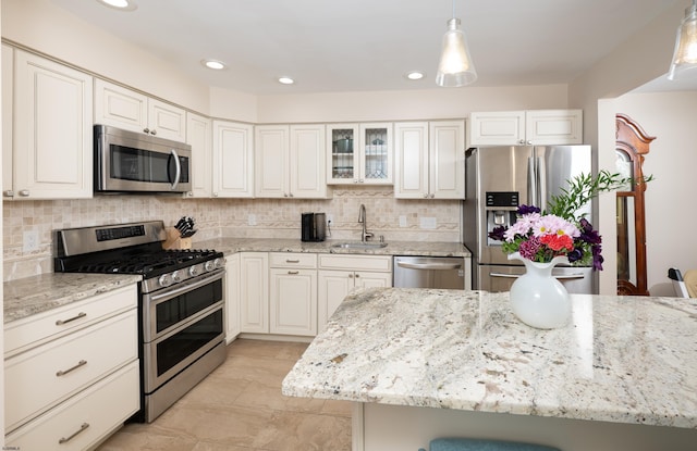 229 Society Hill Blvd Unit 229, Cherry Hill, NJ 08003 - kitchen with stainless steel appliances, light stone counters, hanging light fixtures, tasteful backsplash, and glass insert cabinets