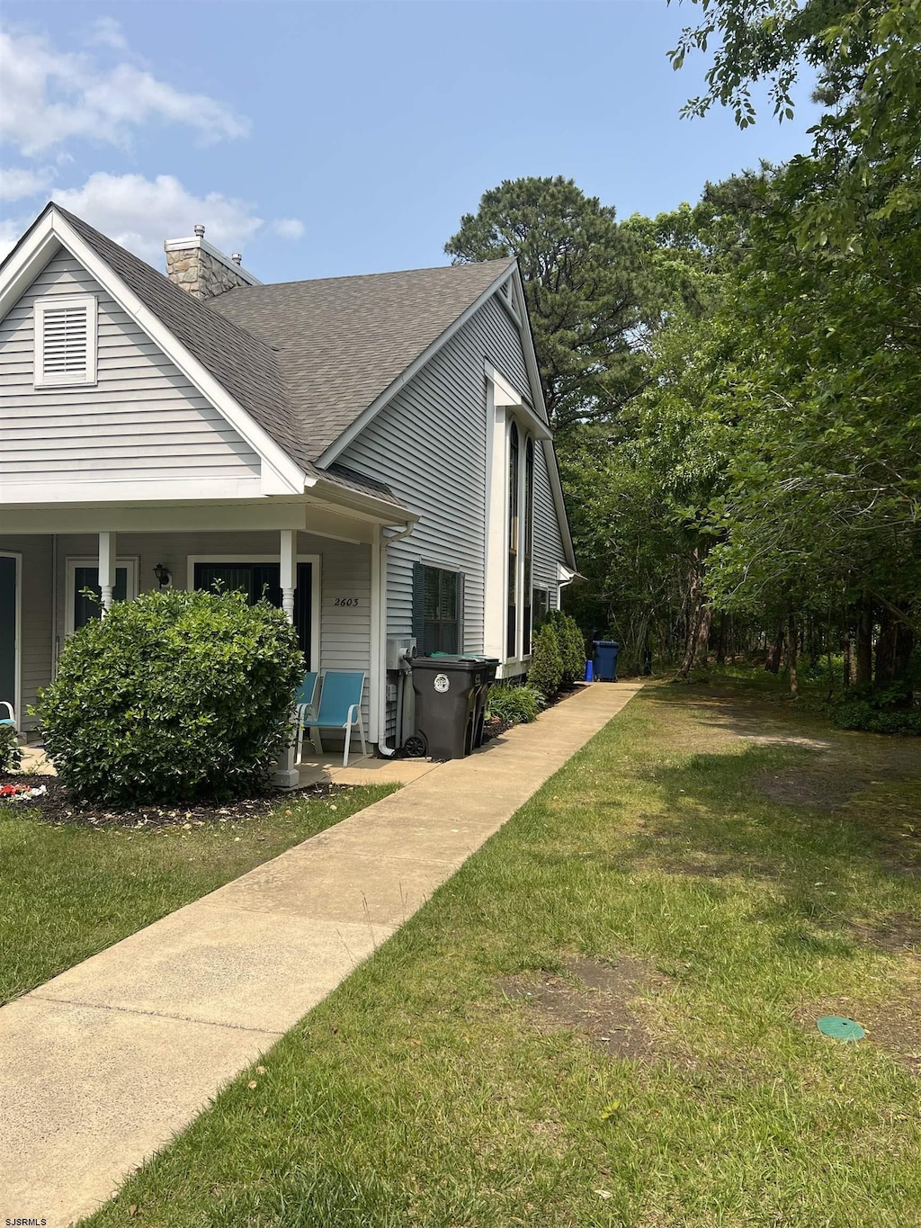 2603 Canyon Ct Unit 2603, Hamilton Township, NJ 08330 - view of side of home with roof with shingles, a lawn, a chimney, and a porch