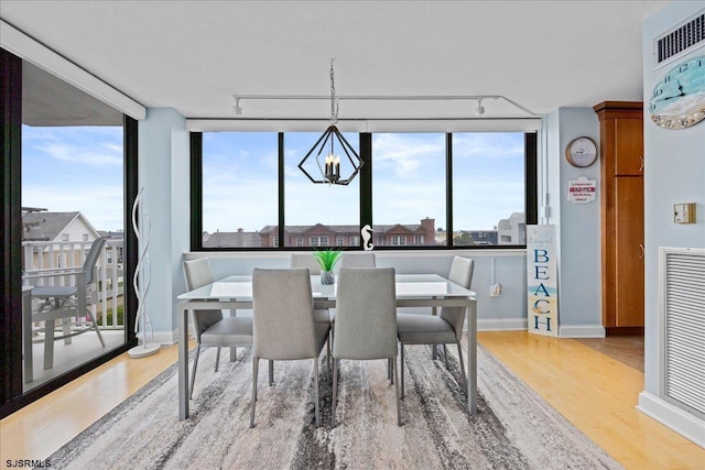 111 S 16th Ave Unit 415, Longport, NJ 08403 - dining room featuring wood finished floors, rail lighting, plenty of natural light, and a chandelier