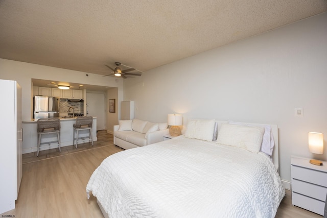 3851 Boardwalk Unit 1805, Atlantic City, NJ 08401 - bedroom featuring freestanding refrigerator, light wood-style flooring, a textured ceiling, and a ceiling fan