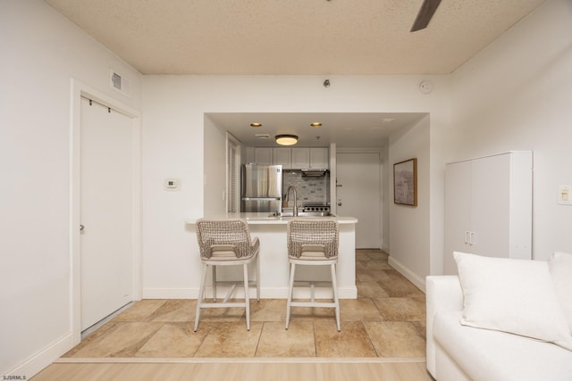 3851 Boardwalk Unit 1805, Atlantic City, NJ 08401 - kitchen featuring freestanding refrigerator, a peninsula, tasteful backsplash, a breakfast bar area, and light countertops