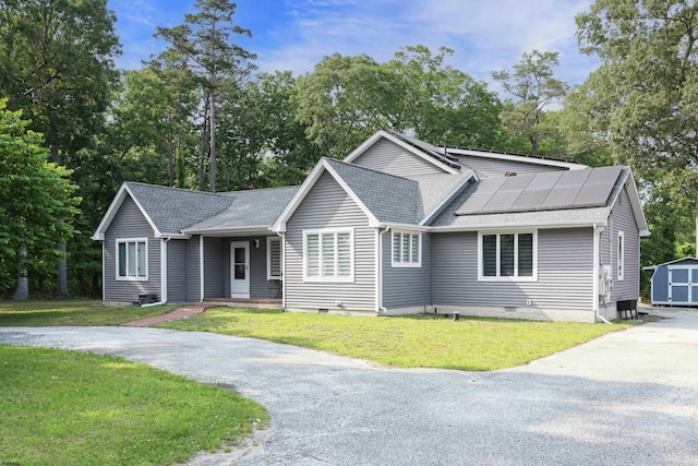 106 Hillside Ave, Absecon, NJ 08201 - ranch-style home featuring a shingled roof, a front lawn, a storage unit, and roof mounted solar panels