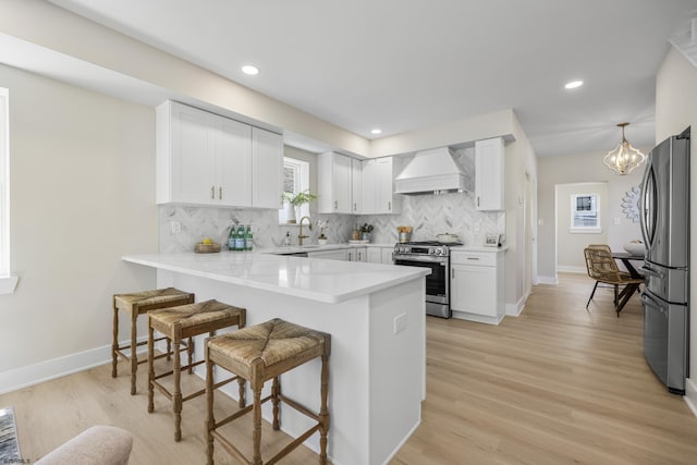 114 N Avolyn Ave, Ventnor, NJ 08406 - kitchen featuring appliances with stainless steel finishes, custom exhaust hood, a breakfast bar, a peninsula, and tasteful backsplash