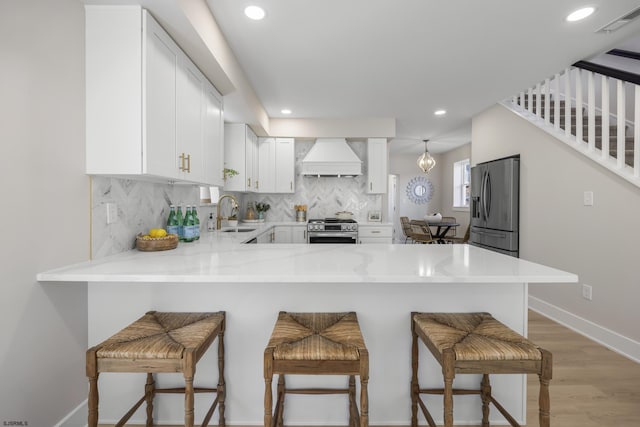 114 N Avolyn Ave, Ventnor, NJ 08406 - kitchen featuring appliances with stainless steel finishes, custom range hood, light countertops, a peninsula, and decorative backsplash