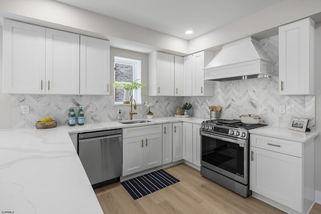 114 N Avolyn Ave, Ventnor, NJ 08406 - kitchen featuring custom range hood, stainless steel appliances, white cabinetry, light stone counters, and light wood-style flooring