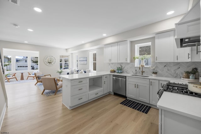 114 N Avolyn Ave, Ventnor, NJ 08406 - kitchen featuring stainless steel dishwasher, a peninsula, light wood-style floors, tasteful backsplash, and light countertops
