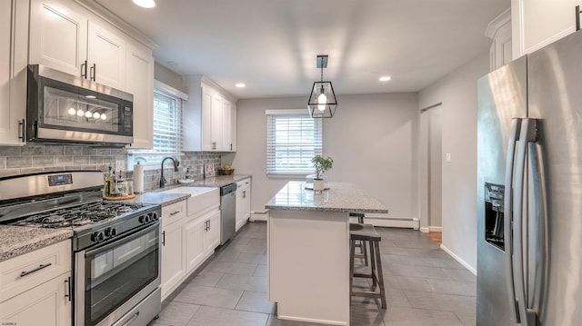 2308 Oak Ave, Northfield, NJ 08225 - kitchen with appliances with stainless steel finishes, a baseboard heating unit, decorative backsplash, a kitchen island, and white cabinets