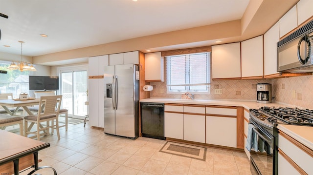 2 S Barclay Ave, Margate, NJ 08402 - kitchen featuring black appliances, light countertops, hanging light fixtures, backsplash, and healthy amount of natural light