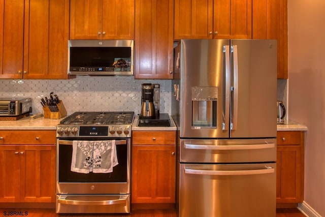 1 Poppy Rd, Egg Harbor Township, NJ 08234 - kitchen featuring appliances with stainless steel finishes, decorative backsplash, brown cabinets, and wood finished floors