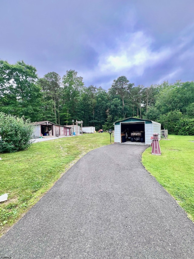 5323 S Carolina Ave, Mullica Township, NJ 08215 - view of front facade featuring an outbuilding, a front lawn, a garage, and a forest view